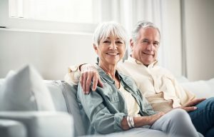 Older couple sitting on couch smiling